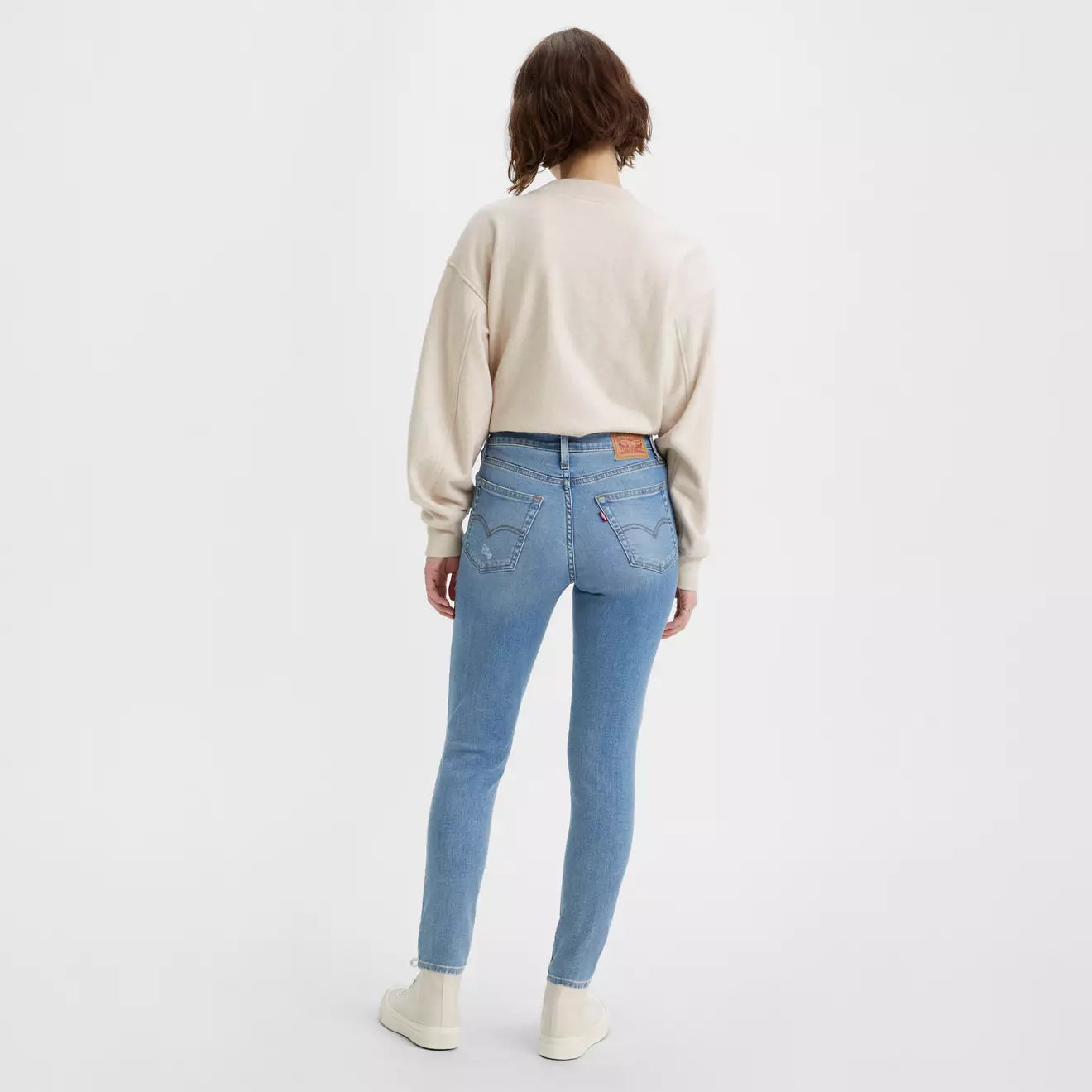 Levi's 721 High Rise Skinny Jeans in light blue with ripped details, showcasing a fitted silhouette and classic denim style.