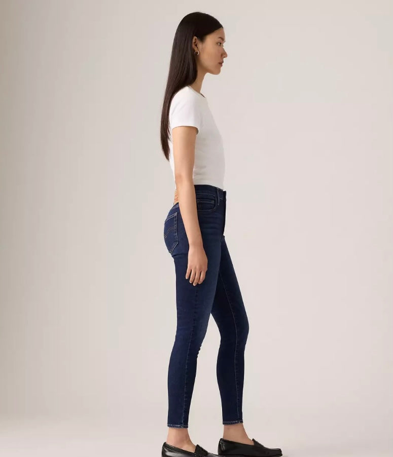 Levi's 720 high-rise super skinny women's jeans in dark wash, showing a close-up of the fitted waistband and denim fabric.