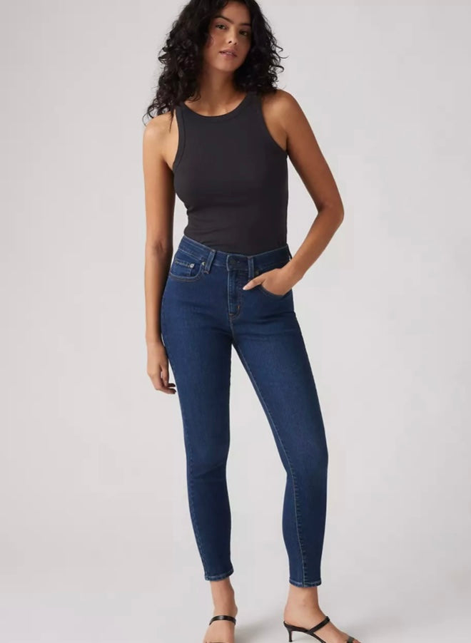 Levi’s 721 High Rise Skinny jeans in dark wash, shown on a model with a casual outfit, highlighting their slim fit and high waist.