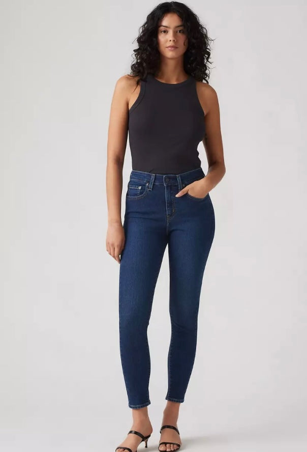 Levi’s 721 high rise skinny jeans in dark denim, displayed on a hanger with a plain background.