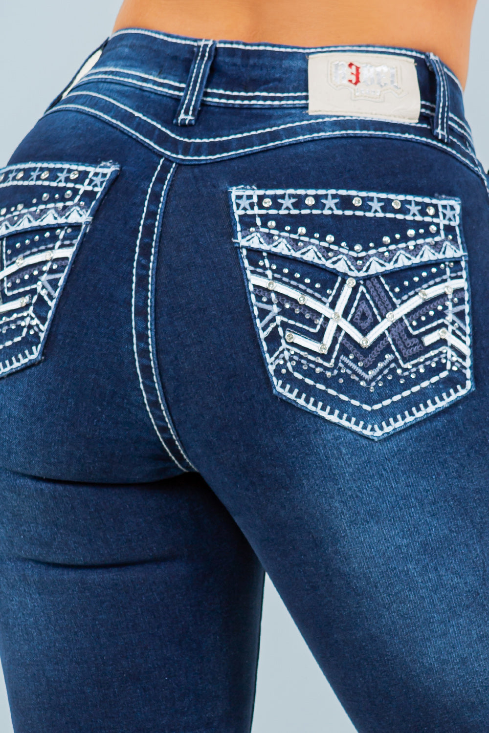 Dark wash Rebel mid-rise bootcut jeans by Diamante Jeans with embroidered accents and contrast stitching, shown on a model.