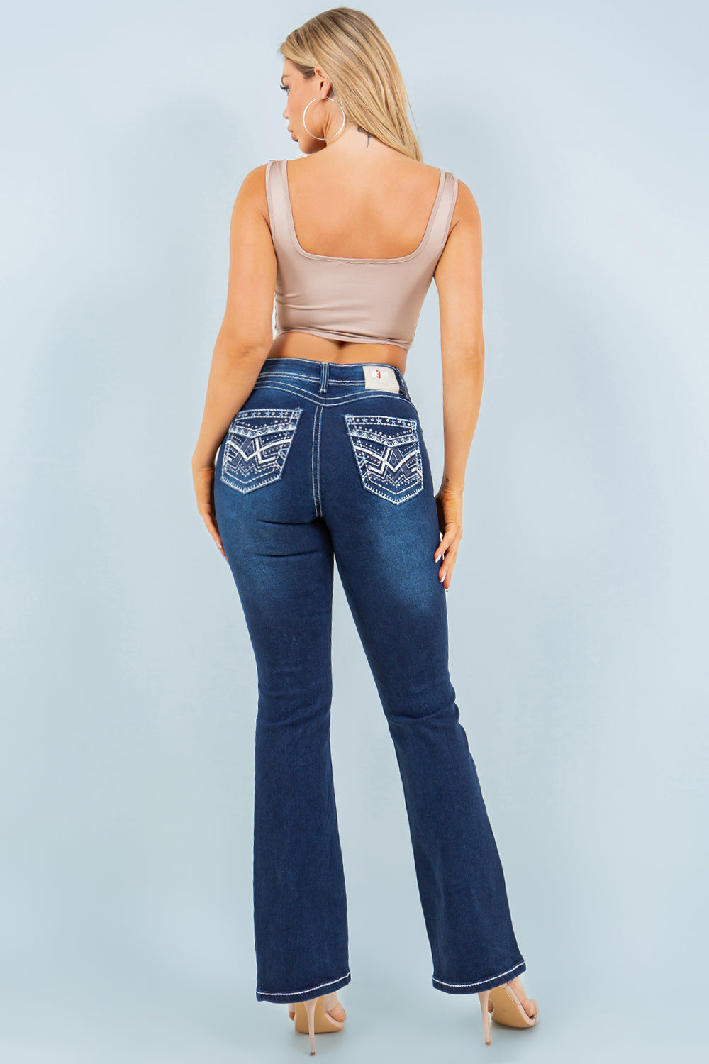 Dark wash Rebel mid-rise bootcut jeans by Diamante Jeans with embroidered accents and contrast stitching, shown on a model.