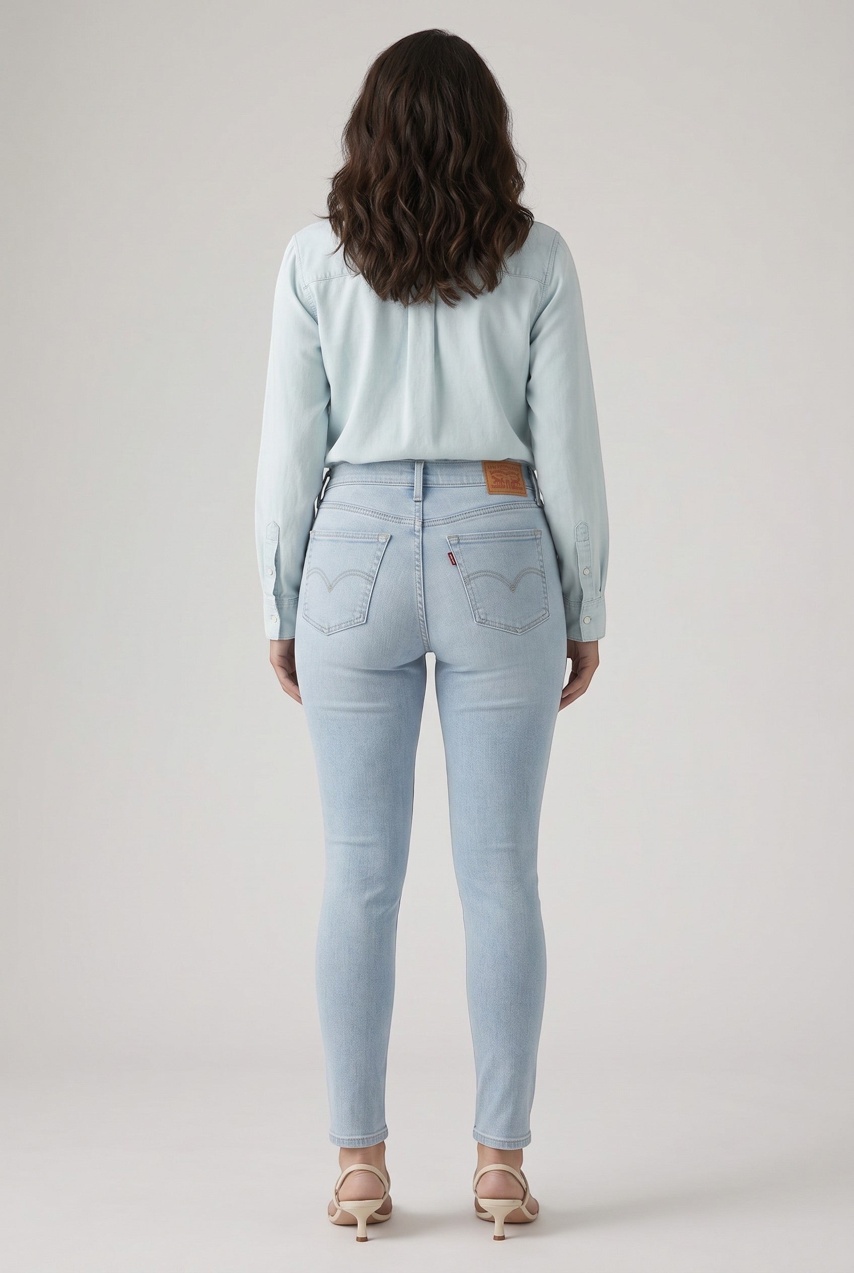 Vella Moda Levi's 711 light wash skinny jeans on a model, back view showing mid-rise fit and five-pocket styling.